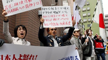 Holding placards and Japanese flags right-wingers demonstrate outside the office of Unplugged Inc., a Japanese distributor of the Academy-award winning film "The Cove" in Tokyo, Japan, Friday, April 9, 2010. 