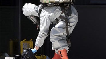A member of the hazardous material team inspects some of the contents of a car belonging to a man arrested by police in Toronto, Canada on Thursday June 24, 2010. Police spokeswoman Nathalie Deschenes said Thursday there was an array of unspecified weapon 