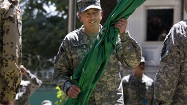 Gen. David Petraeus, the new commander of U.S. and NATO forces in Afghanistan, holds the ISAF flag during a ceremony in which he formally assumed the command, Sunday, July 4, 2010 in Kabul, Afghanistan. 