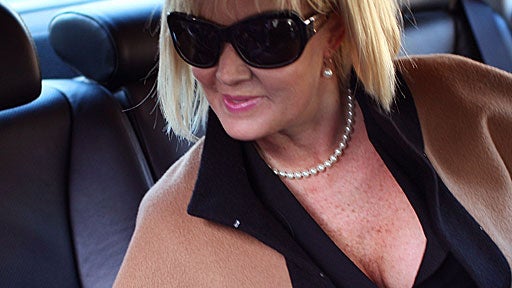 The Wall Street sign is juxtaposed against the sculpture on the facade of the New York Stock Exchange 