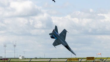 Pilot Capt. Brian Bews parachutes to safety as his CF-18 fighter jet crashes and explodes during a practice flight at the Lethbridge County Airport on Friday, July 23, 2010 for the weekend airshow in Lethbridge, Alberta, Canada. 