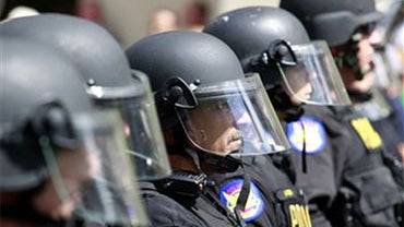 Police form a cordon to block the street Thursday, July 29, 2010 in Phoenix while protesters rally against Arizona's new immigration law, SB1070. Opponents of Arizona's immigration crackdown went ahead with protests Thursday despite a judge's ruling that  