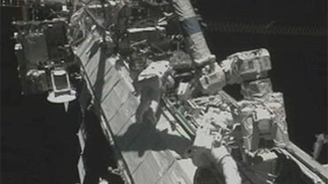 Astronauts Douglas Wheelock (center) and Tracy Caldwell Dyson on a spacewalk to replace a 780-pound ammonia pump module that failed last Saturday, knocking one of the International Space Station's two coolant loops out of action and forcing the crew to im 