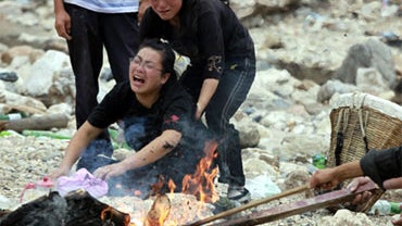 People mourn the death of a relative killed by new landslides in Zhouqu County in China's Gansu Province, Aug. 12, 2010. New downpours have brought yet more mudslides and deaths in an area already ravaged by floods. 