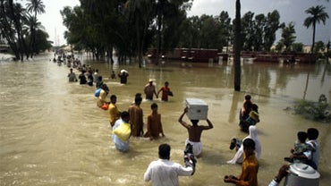 Stranded Pakistanis wade through water for safe areas in Muzaffargarh near Multan, Pakistan, Aug. 13, 2010. Fever, stomach problems and skin diseases are spreading among Pakistani flood  victims. 