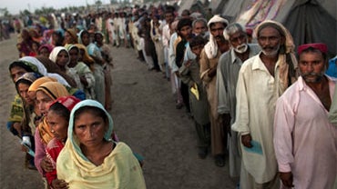 Pakistanis line-up during an aid distribution by the United Nations World Food Program at a camp for families displaced by floods in Sukkar, Sindh province, southern Pakistan, Saturday, Aug. 21, 2010. (AP Photo/Kevin Frayer) 