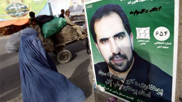 Afghan women walk past election posters in Kabul, Afghanistan, Monday, Aug. 23, 2010. Afghans will go to the polls for parliamentary elections in September. After a fraud-ridden presidential election last year that nearly undermined President Hamid Karzai 