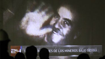 Relatives and journalists watch new images of the miners in Copiapo, Chile,Thursday, Aug. 26, 2010. The images were shown to relatives and handed to local TV stations by authorities Thursday. (AP Photo/ Roberto Candia) 