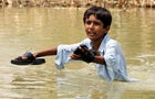 A Pakistani boy living in a village separated from main roads due to floods beg for relief goods from the Pakistan Army at Godar Chawk in Muzaffargarh district, Punjab Province, Pakistan, Aug. 27, 2010. 