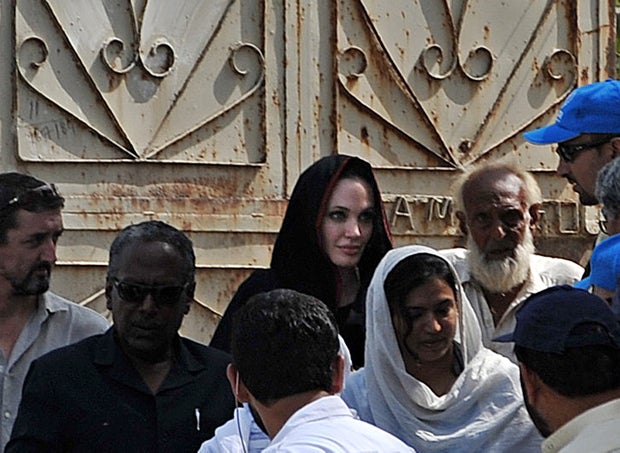 Actress and UNHCR Goodwill Ambassador Angelina Jolie (in black scarf) leaves after a visit to a makeshift camp for Pakistani flood victims in the Mohib Bhanda area of Nowshera district on Sept. 7, 2010.  (A. MAJEED/AFP/Getty) Images) 
