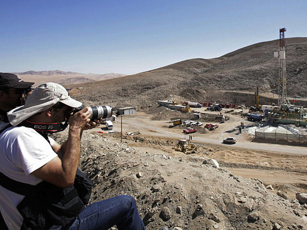 Photographers take pictures of the site where rescue operations for 33 trapped miners continue at the San Jose mine near Copiapo, Chile, Monday Oct. 11, 2010. Rescuers on Monday finished reinforcing the hole drilled to bring 33 trapped miners to safety an 