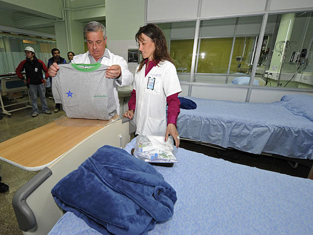 Chile's Health Minister Jaime Manalich inspects clothing that will be given to the miners after they are rescued and evacuated as Dr. Paola Neumann, health director for the Atacama region, looks on at a hospital in Copiapo, Chile, Monday Oct. 11, 2010. Re 