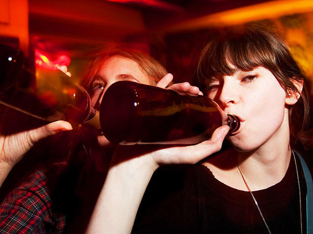 young women binge drinking at bar 