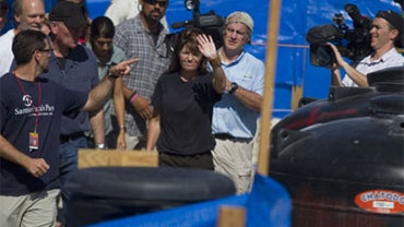 Former Alaska Gov. Sarah Palin, center, waves to the press during her visit at a cholera treatment center set up by the NGO Samaritan's Purse in the slum of Cite Soleil in Port-au-Prince, Haiti, Sunday Dec. 12, 2010. 