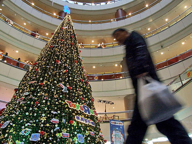 Chinese man walks past a Christmas tree at a department store in Shanghai, China, December 15, 2008.(Imaginechina via AP Images) 