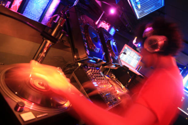 DJ spins records at nightclub rave dance party 
