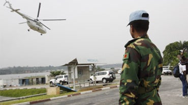 A UN soldier looks on as a helicopter takes off inside the UN Headquarters in Abidjan, Ivory Cost, Friday, Dec. 31, 2010. 