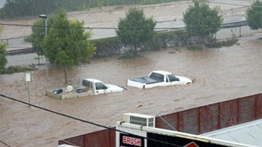 Two vehicles are abandoned on a street in Toowoomba, Australia, during a flash flood Monday, Jan. 10, 2011. Flash floods swept through the northeastern Australian community Monday, overturning cars and flinging a van against several trees as relentless ra 
