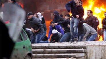 Opposition protesters throw stones at police after a pro-opposition rally Friday, Jan. 21, 2011. More than 20,000 people attended a rally organized by the socialist party to demand that that conservative Prime Minister Sali Berisha call early elections be 