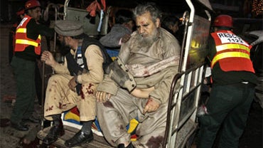 Injured people are taken away in a rickshaw from the site of a suicide bombing in Lahore, Pakistan, Tuesday, Jan. 25, 2011. A suicide bomber blew himself up near a march by minority Shiite Muslims in the eastern Pakistani city of Lahore on Tuesday, killin 
