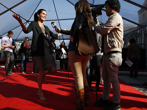 Actress Angie Harmon, left, does an interview on red carpet during setup for the SAG Awards at the Shrine Auditorium in Los Angeles on Saturday, Jan. 29, 2011. (AP Photo/Jason Redmond) ________________________________________ 