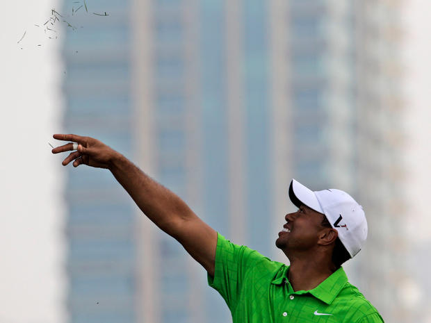 Tiger Woods throws grass in the air at Dubai Desert  
