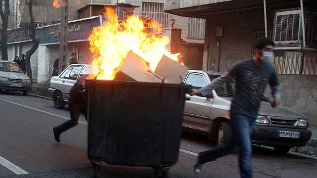 This photo, taken by an individual not employed by the Associated Press and obtained by the AP outside Iran shows Iranian protestors moving a garbage can which is set on fire, during an anti-government protest in Tehran, Iran. 