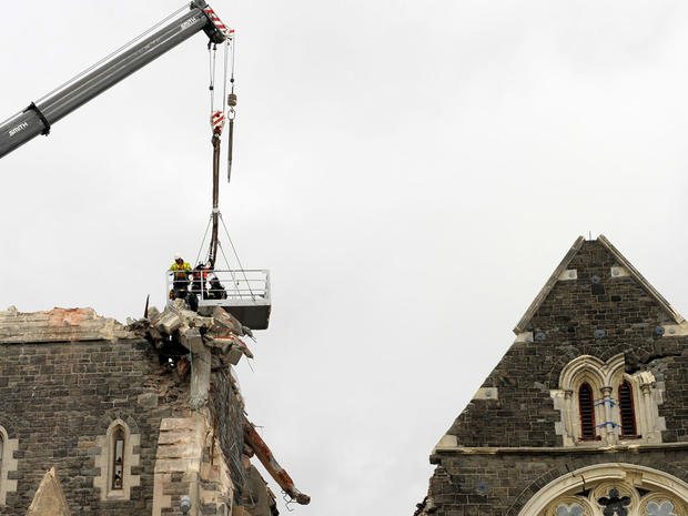Recovery operation workers are lowered by a crane onto the top of the Christchurch Cathedral 