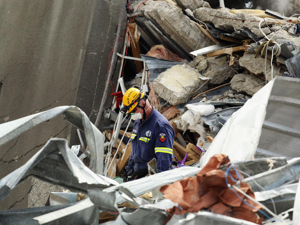rescue worker checks the remains of the CTV building 