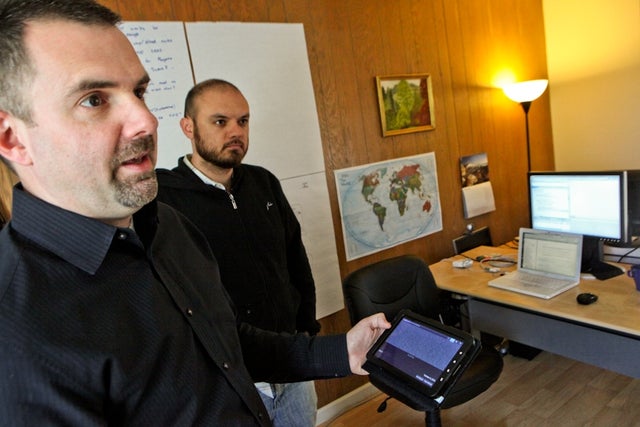 Francis Potter, founder and chief executive of The Hathersage Group, shows off the setiQuest Explorer mobile app he developed. Blake Barrett, application architect at the firm, (at right) helped him on the project. 