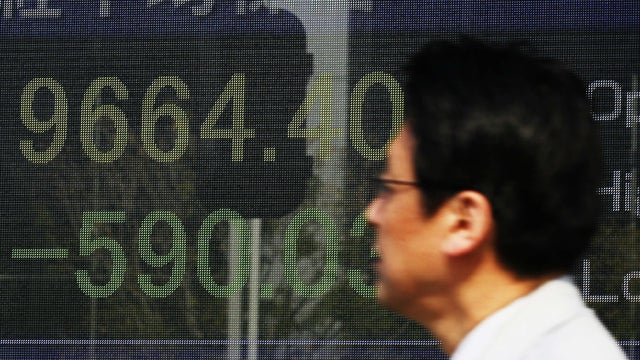 Japanese man watches stock prices in Tokyo 