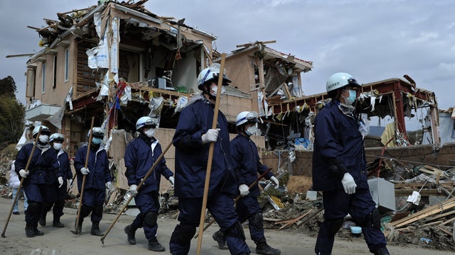 Japan rescue workers walk amid debris in Iwate prefecture 