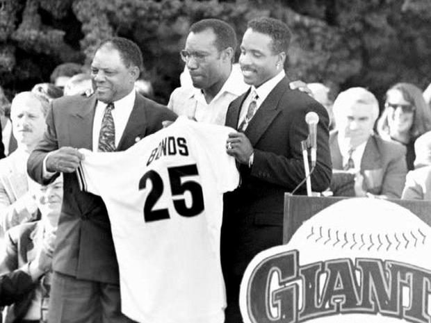 Willie Mays (L), Bobby Bonds (C) and Barry Bonds hold up the No. 25 jersey  