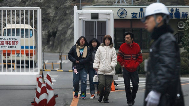Survivors walk outside the Onagawa Nuclear Power Station 