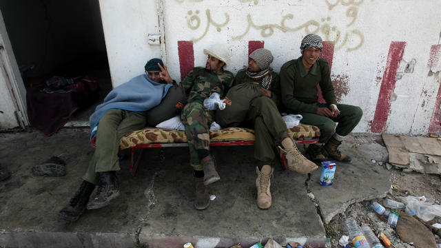 Libyan rebels rest in Uqayla, 20 kms (12 miles) east of Ras Lanuf, on March 30, 2011 