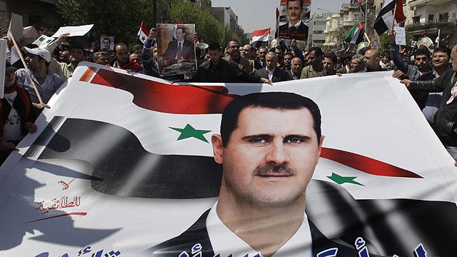 Pro-Syrian President Bashar Assad supporters hold Assad's poster with Arabic words reading: &amp;amp;quot;I'll not kneel as long as you are my leader,&amp;amp;quot; as they demonstrate to show their support for their President, in Damascus, Syria, on Marc 