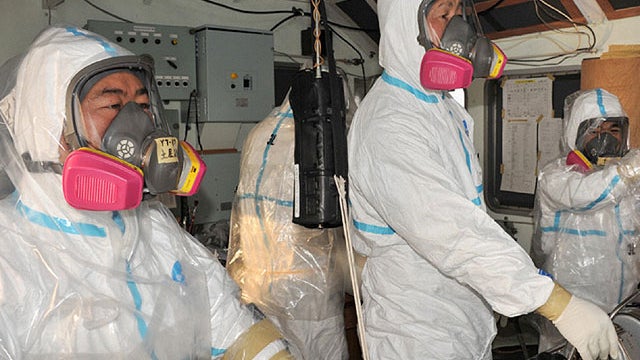 Members of the Japanese Maritime Self-Defense Force steer a tugboat towing a barge, provided by the U.S. Navy, to transport fresh water to spray on crippled reactors at the Fukushima Daiichi Nuclear Power Station, on March 31, 2011.  
