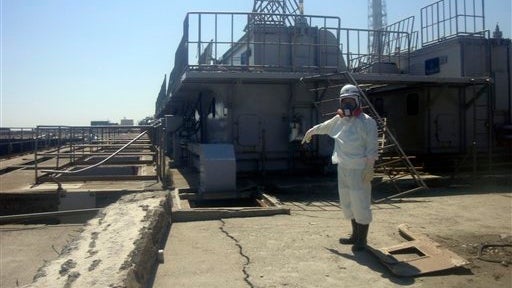 In this Friday, April 1, 2011 photo released by Tokyo Electric Power Co. (TEPCO), a TEPCO employee points at a crack newly discovered in a maintenance pit on the edge of the Fukushima Dai-ichi nuclear nuclear power plant in Okumamachi, Fukushima Prefectur 