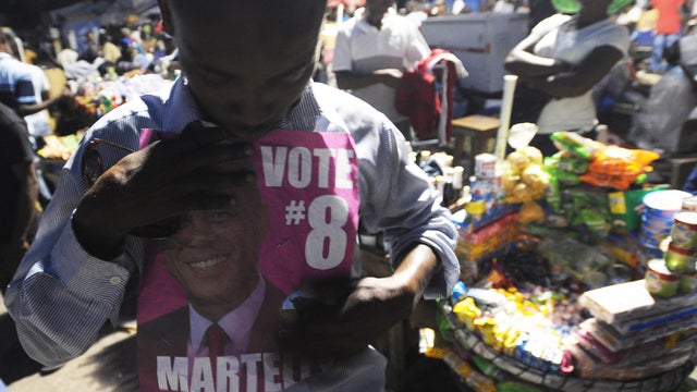 Haitian man shows a photo of election winner Michel Martelly 