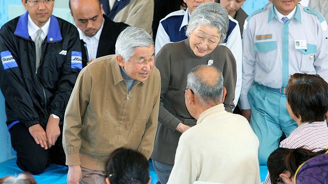 Japanese Emperor Akihito, left, and Empress Michiko, kneel down and smile at people at an evacuation shelter in Asahi City in Chiba Prefecture, about 86 kilometers east of Tokyo, Thursday, April 14, 2011.  