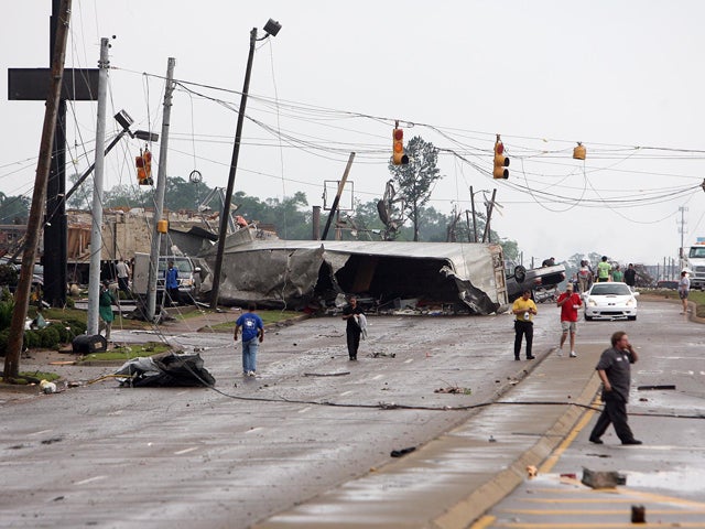 An semi-truck lies on its side 