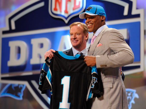 Auburn Quarterback Cam Newton holds up a jersey with NFL commissioner Roger Goodell  