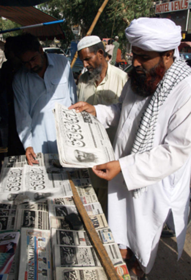 People at a news stand read headlines "Osama bin Laden killed" in Hyderabad, Pakistan 