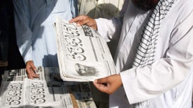People at a news stand read headlines "Osama bin Laden killed" in Hyderabad, Pakistan 
