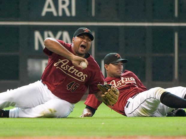 Carlos Lee reacts after colliding with shortstop Angel Sanchez 