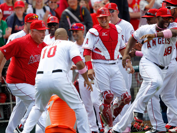Mike Scioscia left, chases after Torii Hunter  
