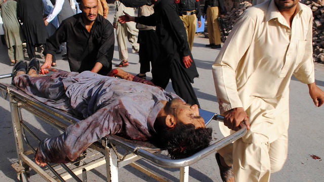 An injured man is rushed to a local hospital in Peshawar after a bombing 
