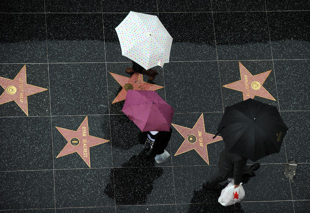 Pedestrians walk under the rain on the stars of the Hollywood Walk of Fame in Hollywood 