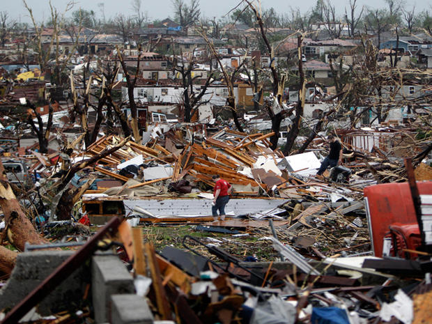Meghan Miller stands in the middle of a destroyed neighborhood  