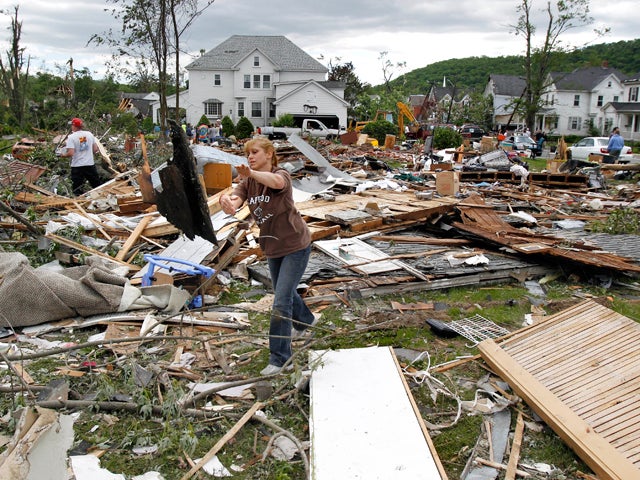 Charlene Meacham tosses a piece of wood at her sister-in-law's leveled home 
